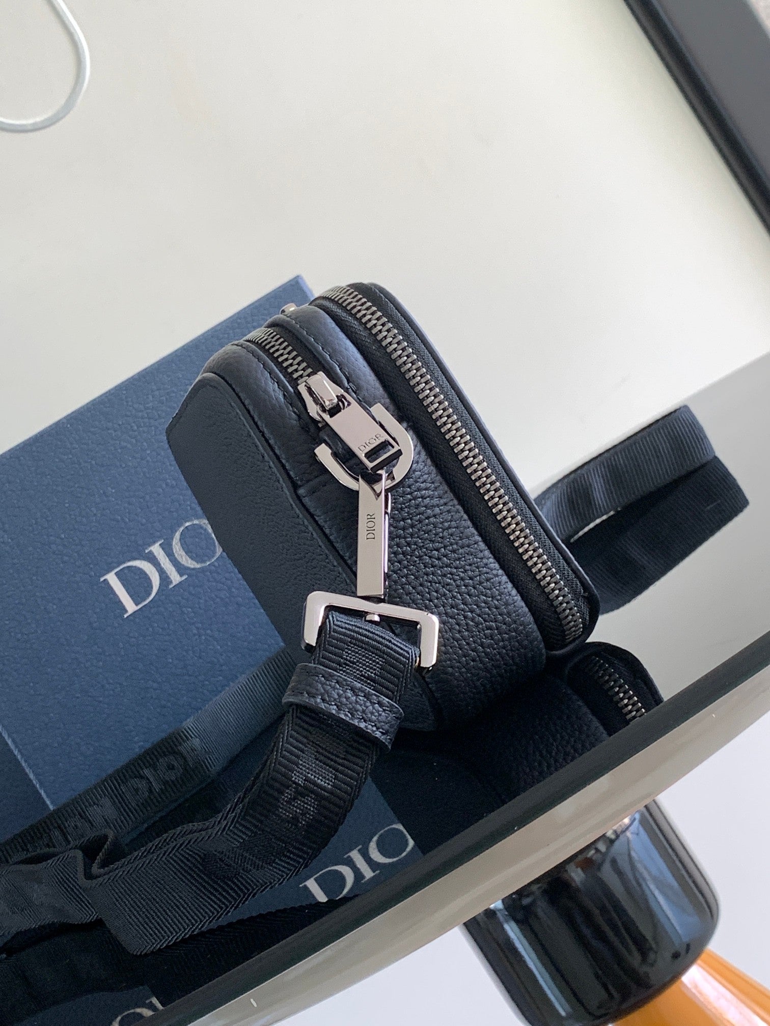 Crossbody bag with zip closure, textured dark blue leather, silver buckles and strap