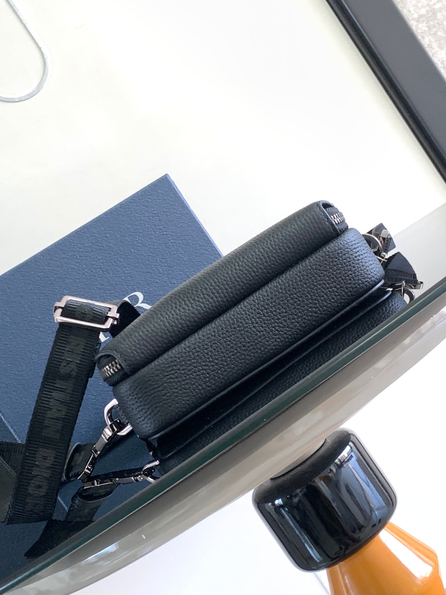 Slim zip crossbody bag in textured dark blue leather with wide strap and silver hardware