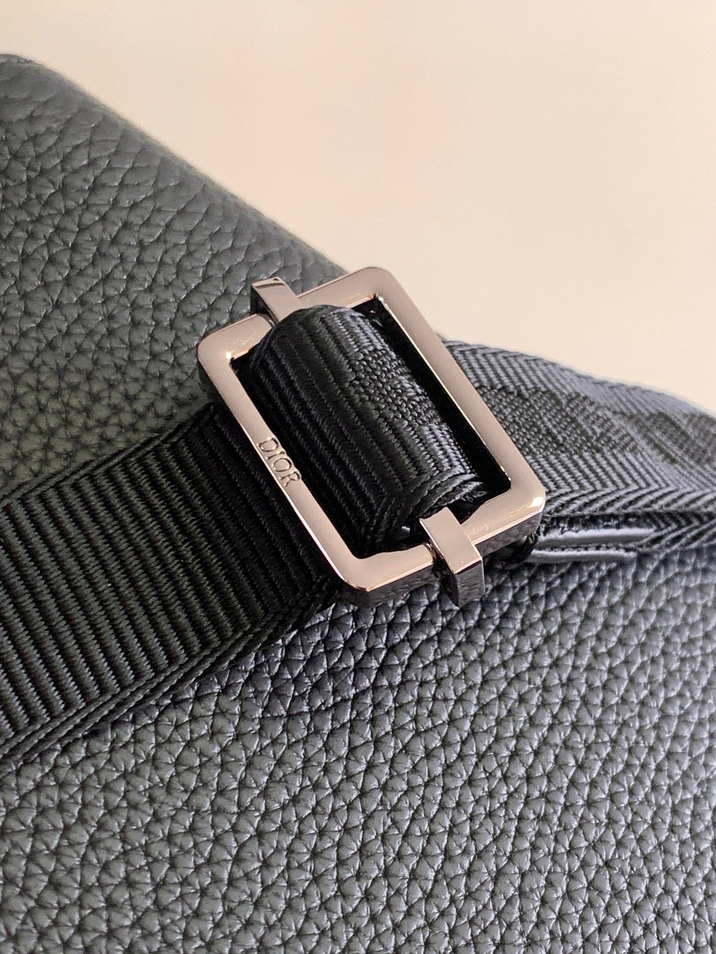 Textured dark blue leather strap attachment with silver buckle and loop hardware