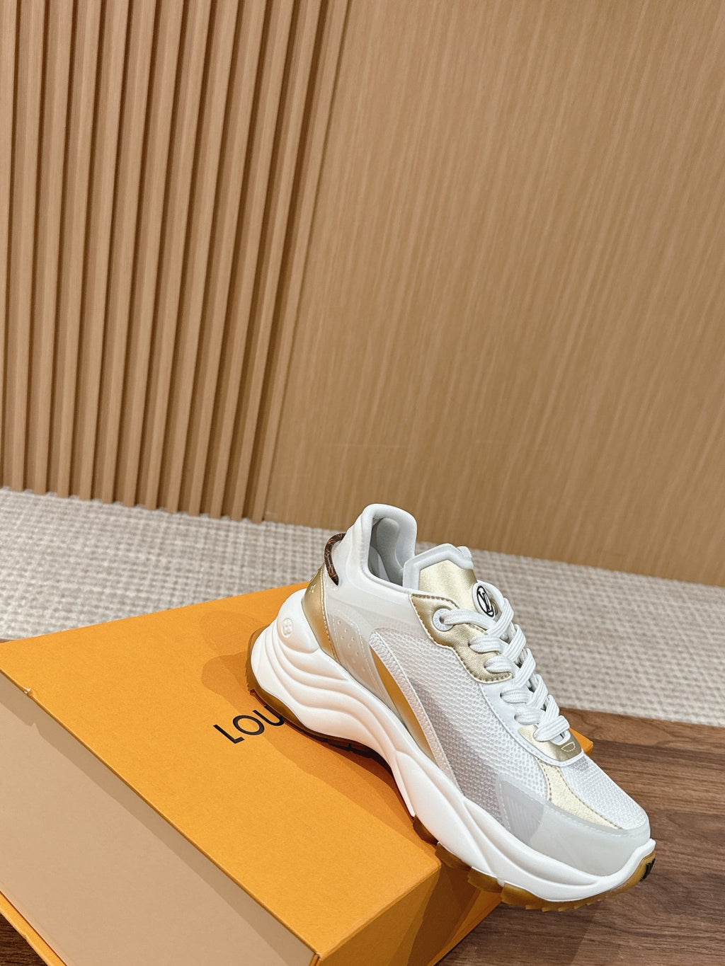 White Louis Vuitton unisex sneaker with gold logo accent and lace-up