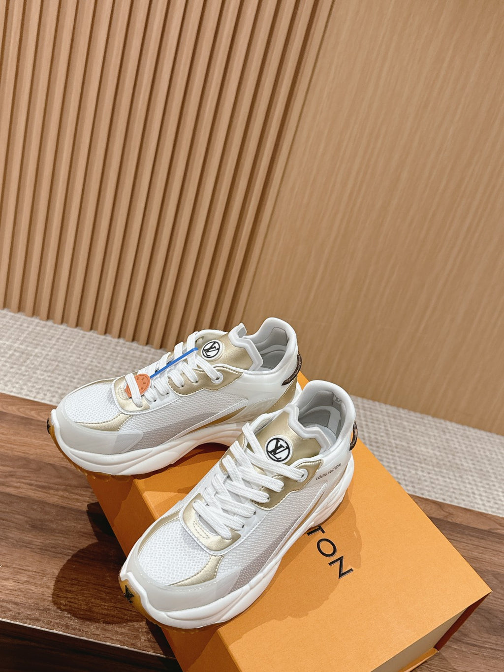 White Louis Vuitton unisex sneakers with gold emblem details and lace-up front