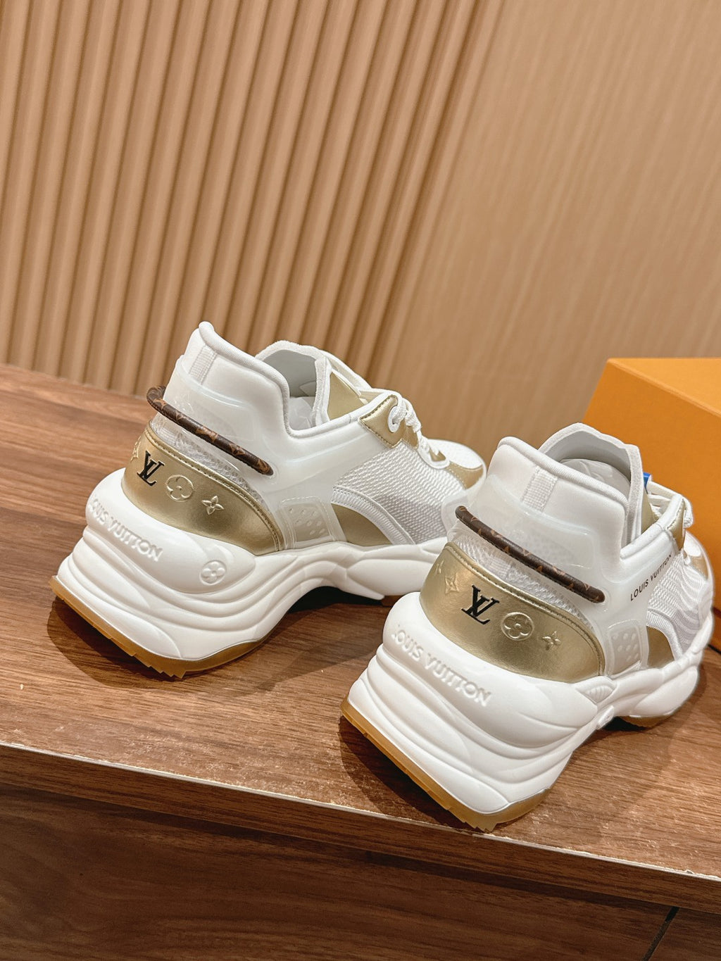 White Louis Vuitton unisex sneakers rear view with chunky sole and gold logo