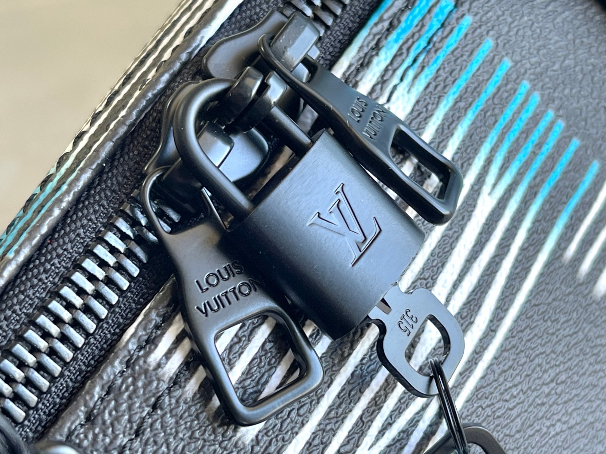 Louis Vuitton duffel bag strap hardware with metal rings and stitched trim detail