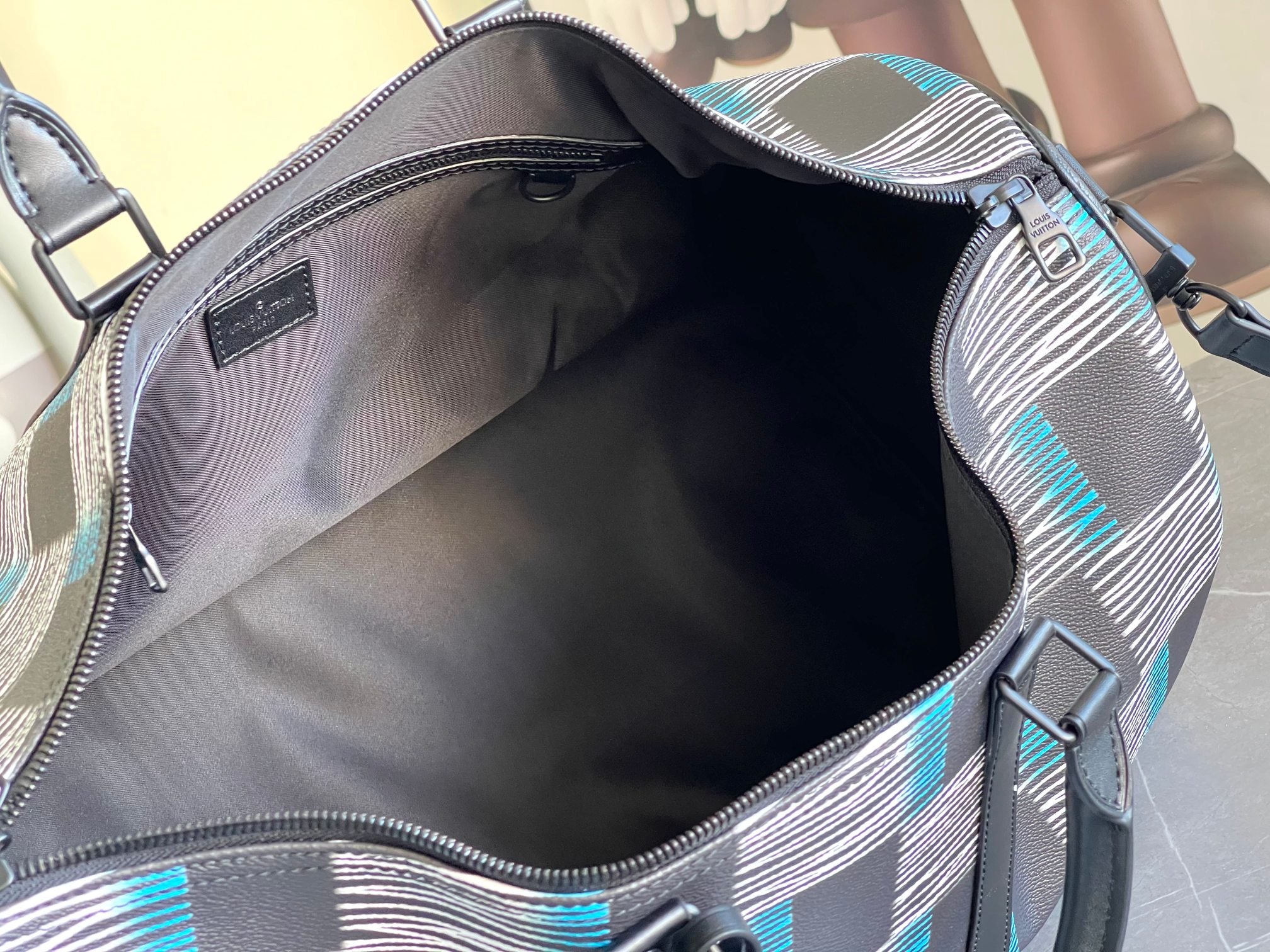 Louis Vuitton duffel bag interior view with open top and navy, blue and white check trim