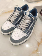 Amiri low-top sneakers pair, front view, dark gray-blue and white with lace-up