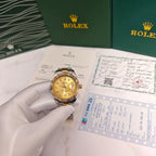 Rolex Day-Date watch on a hand with gold dial, two-tone bracelet, beside paperwork