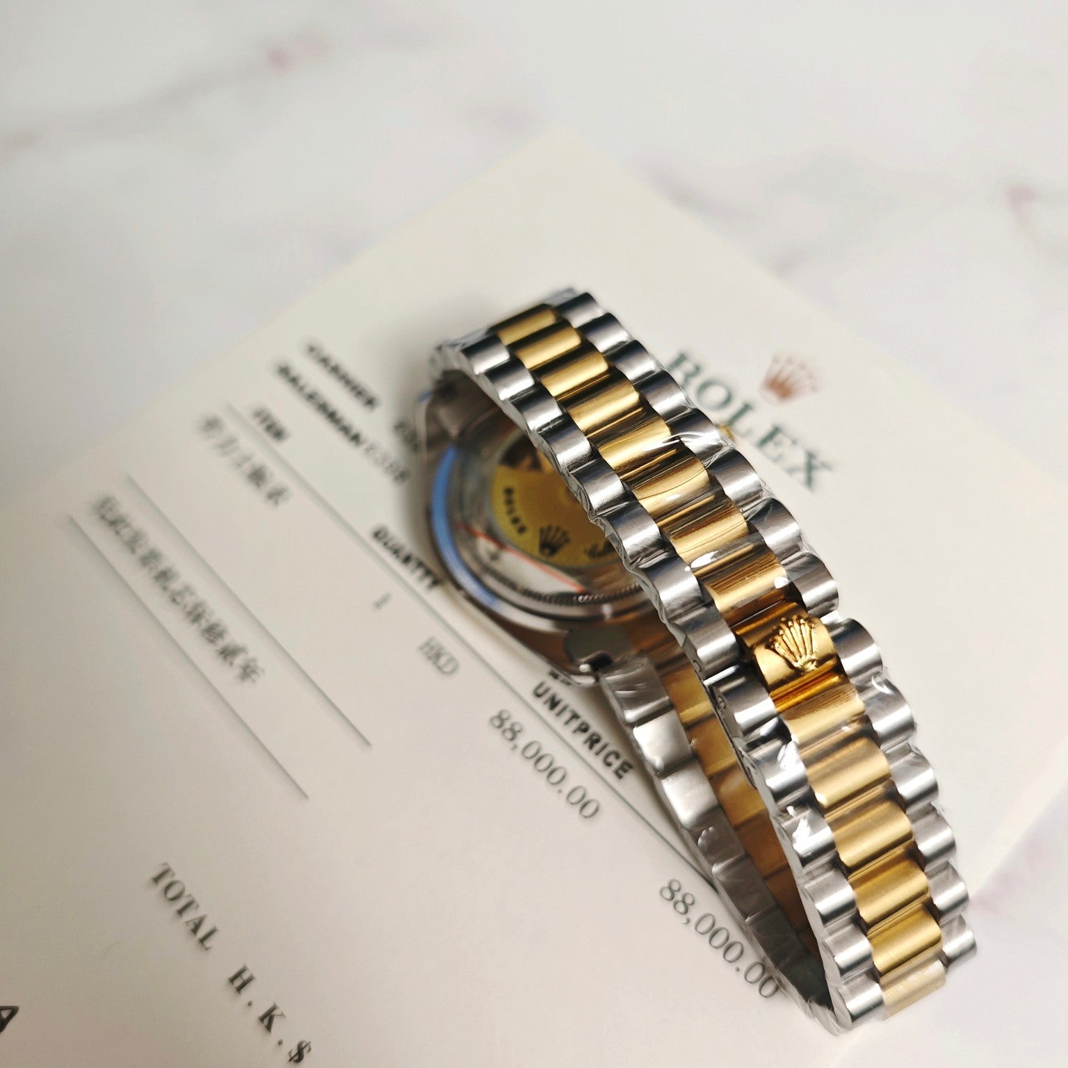 Rolex Day-Date bracelet and case side, two-tone gold and steel links on documents