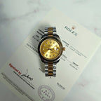 Rolex Day-Date watch with gold dial and two-tone bracelet on certificate card