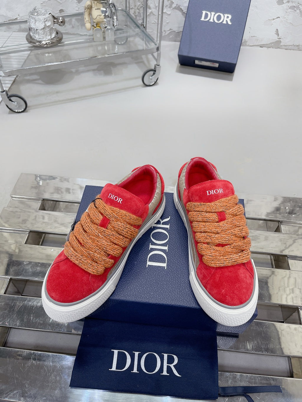 Red suede sneakers, tan rope laces, white sole, Dior logo on side