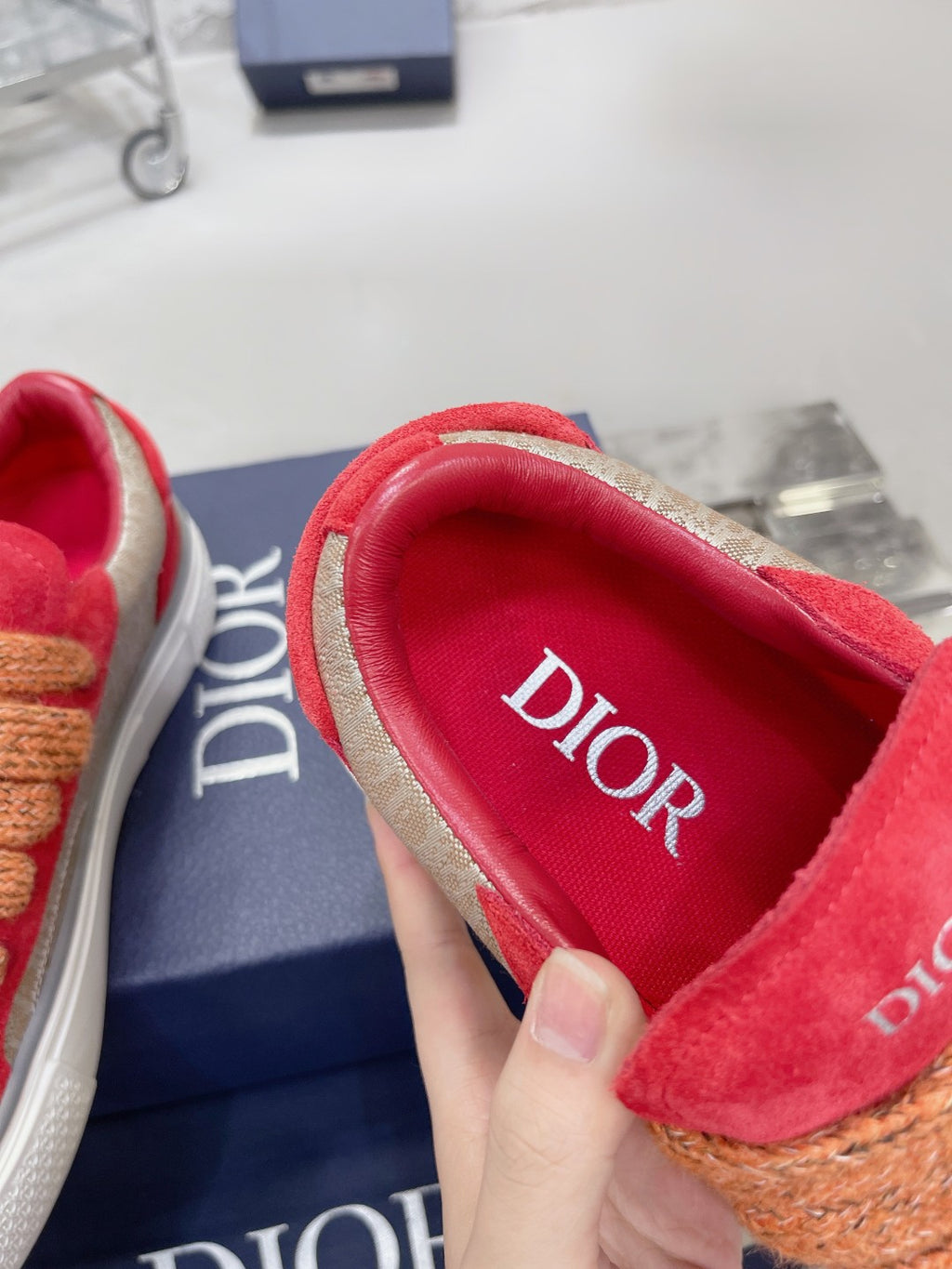 Red suede sneaker interior with Dior-printed lining and tan rope laces