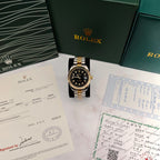 Rolex two-tone wristwatch with black dial, fluted gold bezel, and date window