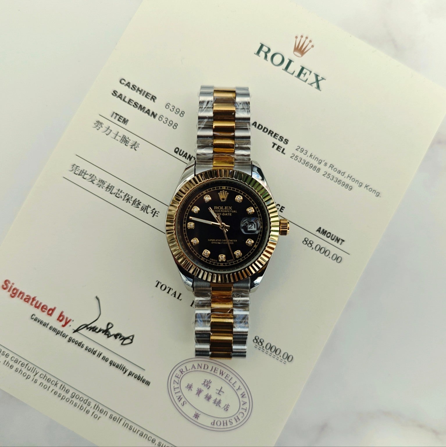 Rolex two-tone wristwatch on paperwork, black dial with gold hour markers and hands
