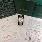 Rolex two-tone watch with gold bezel, silver dial, and striped gold-and-steel bracelet