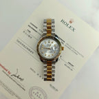 Rolex two-tone watch close-up with silver dial, gold accents, and diamond bezel