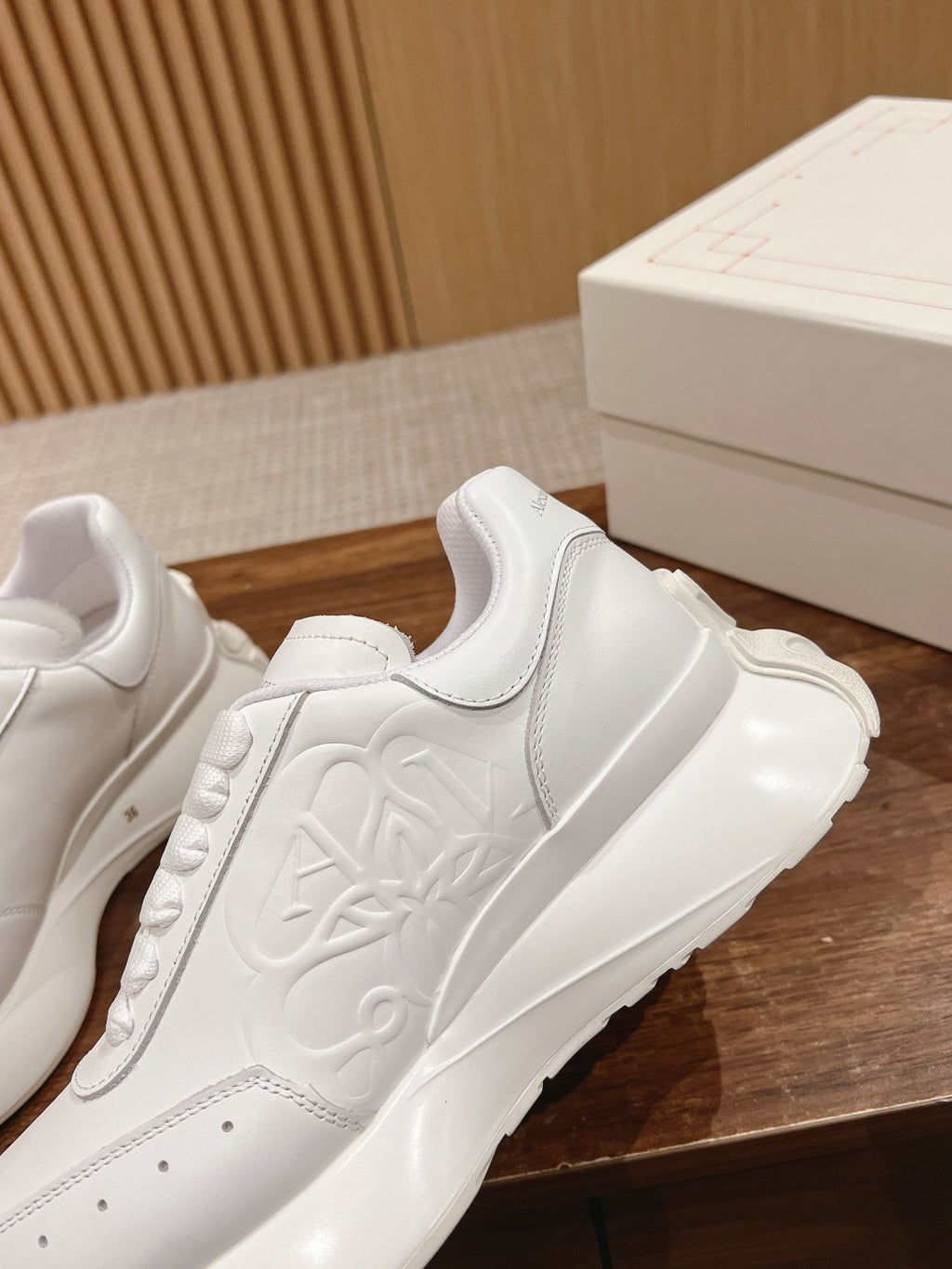 Alexander McQueen white sneakers, embossed logo panel and lace-up stitching detail