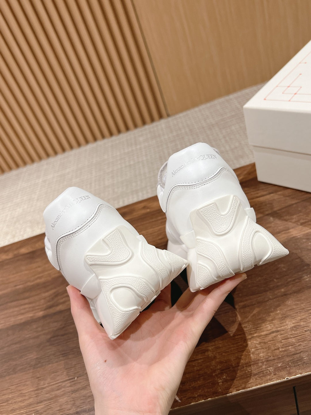 Alexander McQueen white sneakers, close-up rear view with heel tabs and tread