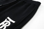 Black jogger pants with large white Burberry letter print