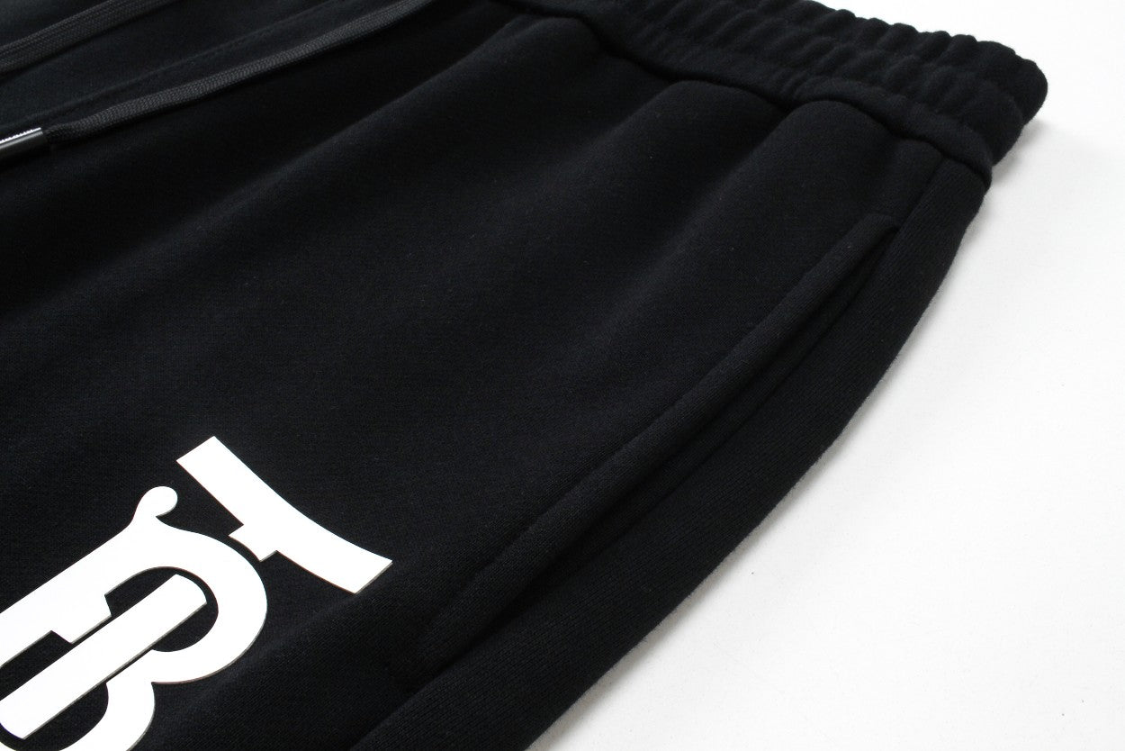 Black jogger pants with large white Burberry letter print