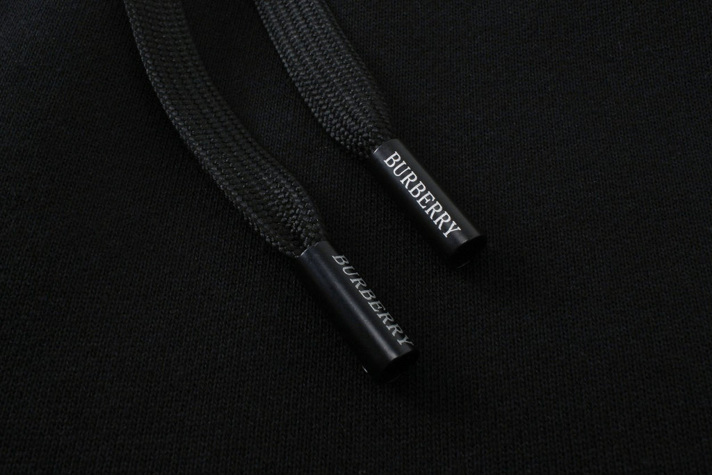 Inside waistband label on black Burberry track pants