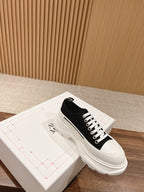 Black Alexander McQueen lace-up sneaker with white laces and chunky sole