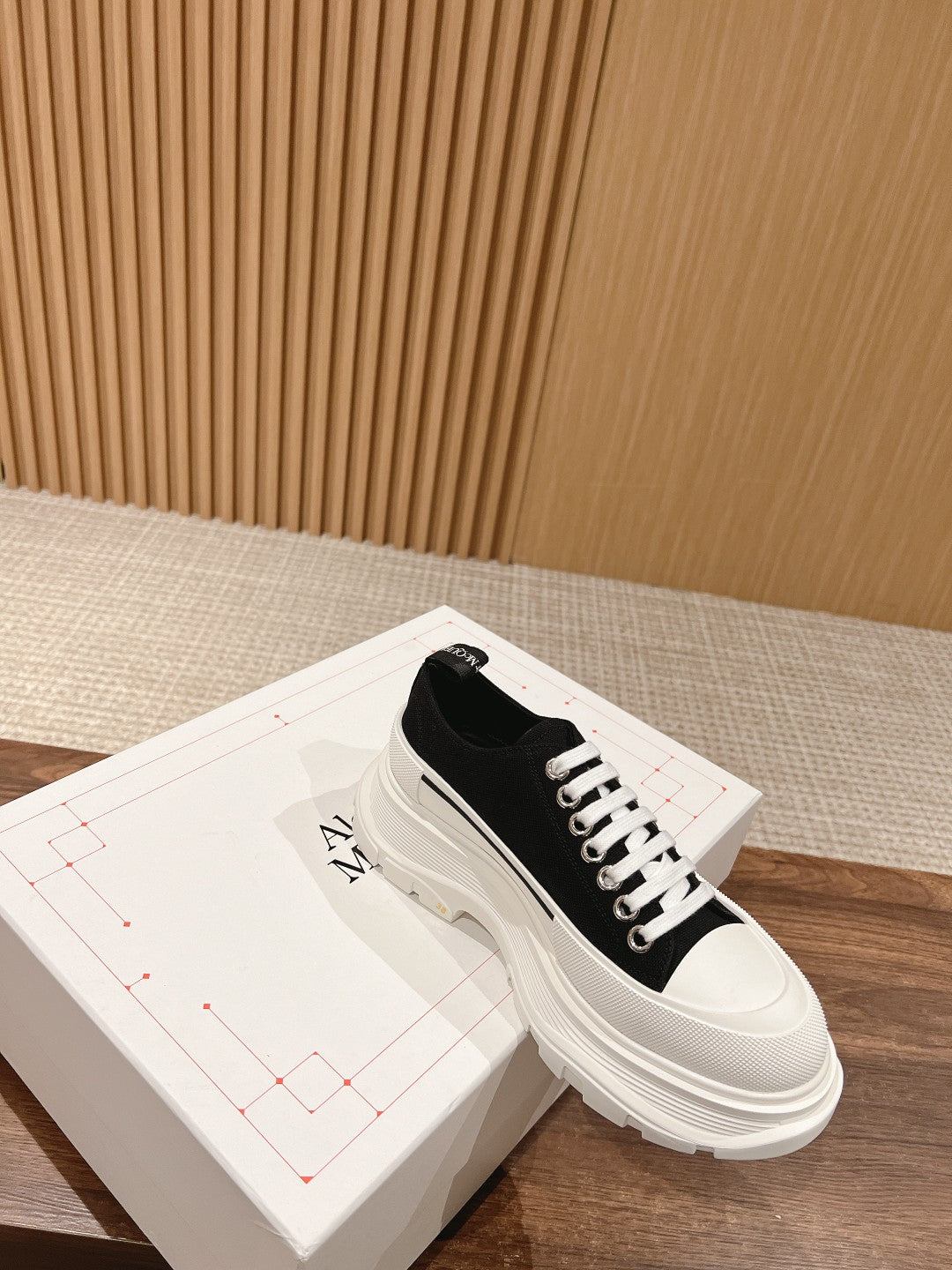 Black Alexander McQueen lace-up sneaker with white laces and chunky sole
