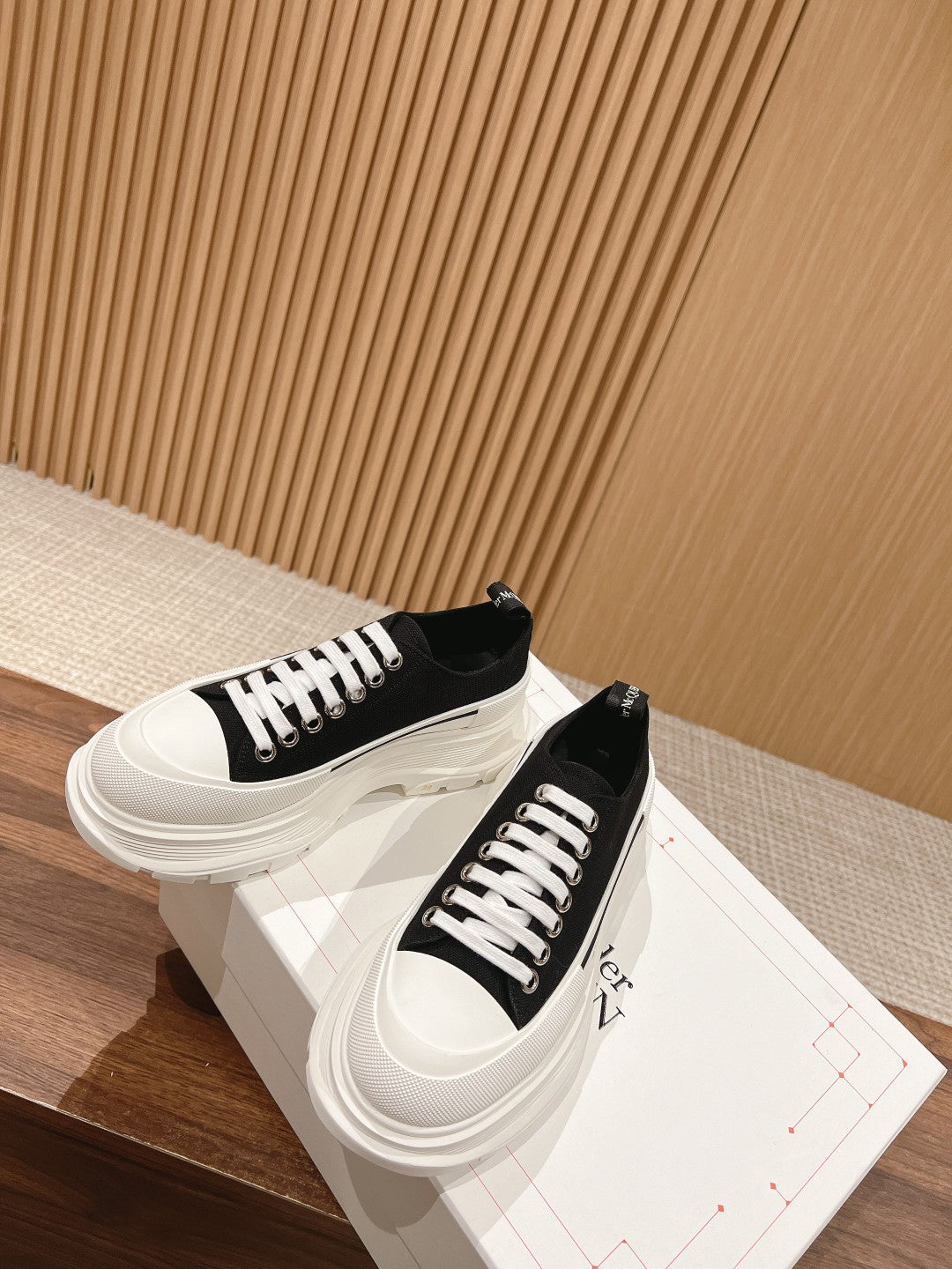 Black and white Alexander McQueen lace-up sneakers, angled side views