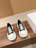 Black and white Alexander McQueen lace-up sneakers, two shoes on display