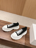 Black and white Alexander McQueen lace-up sneakers with white laces and thick sole