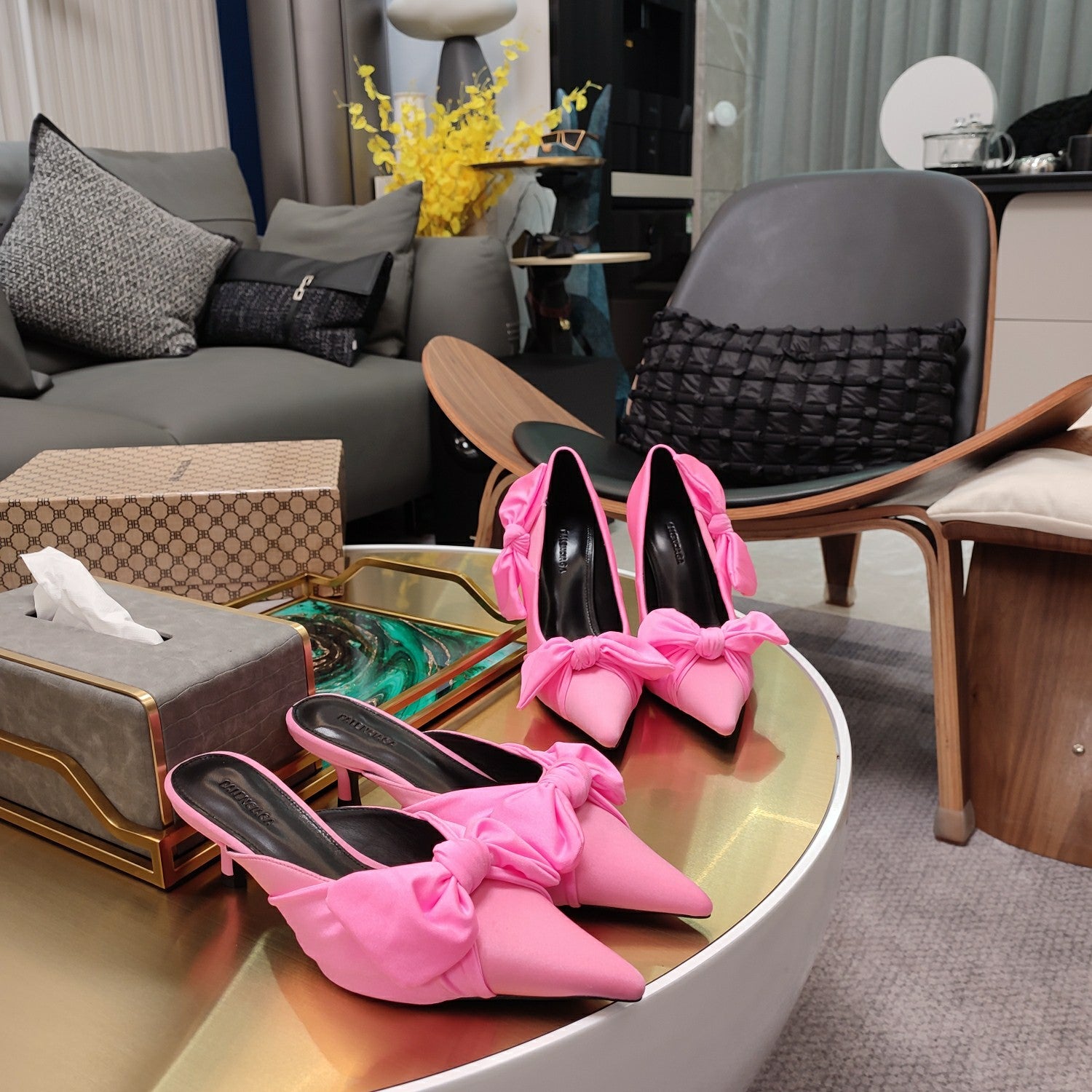 Pink Balenciaga bow sandals with pointed toe and stiletto heel, on display