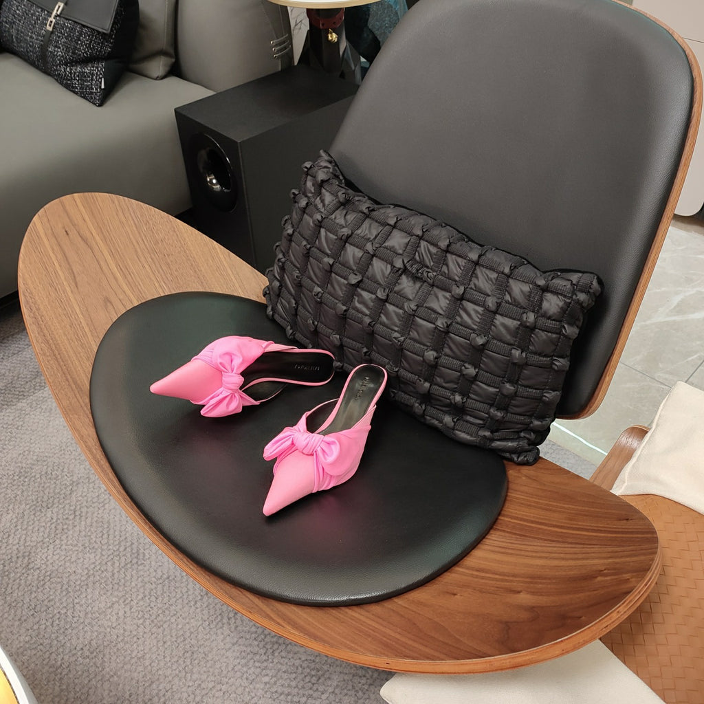 Pink Balenciaga sandals with knotted bow straps and pointed toe, pair on seat