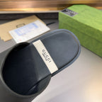 Gucci black leather mule sandal heel view with white logo tag on footbed