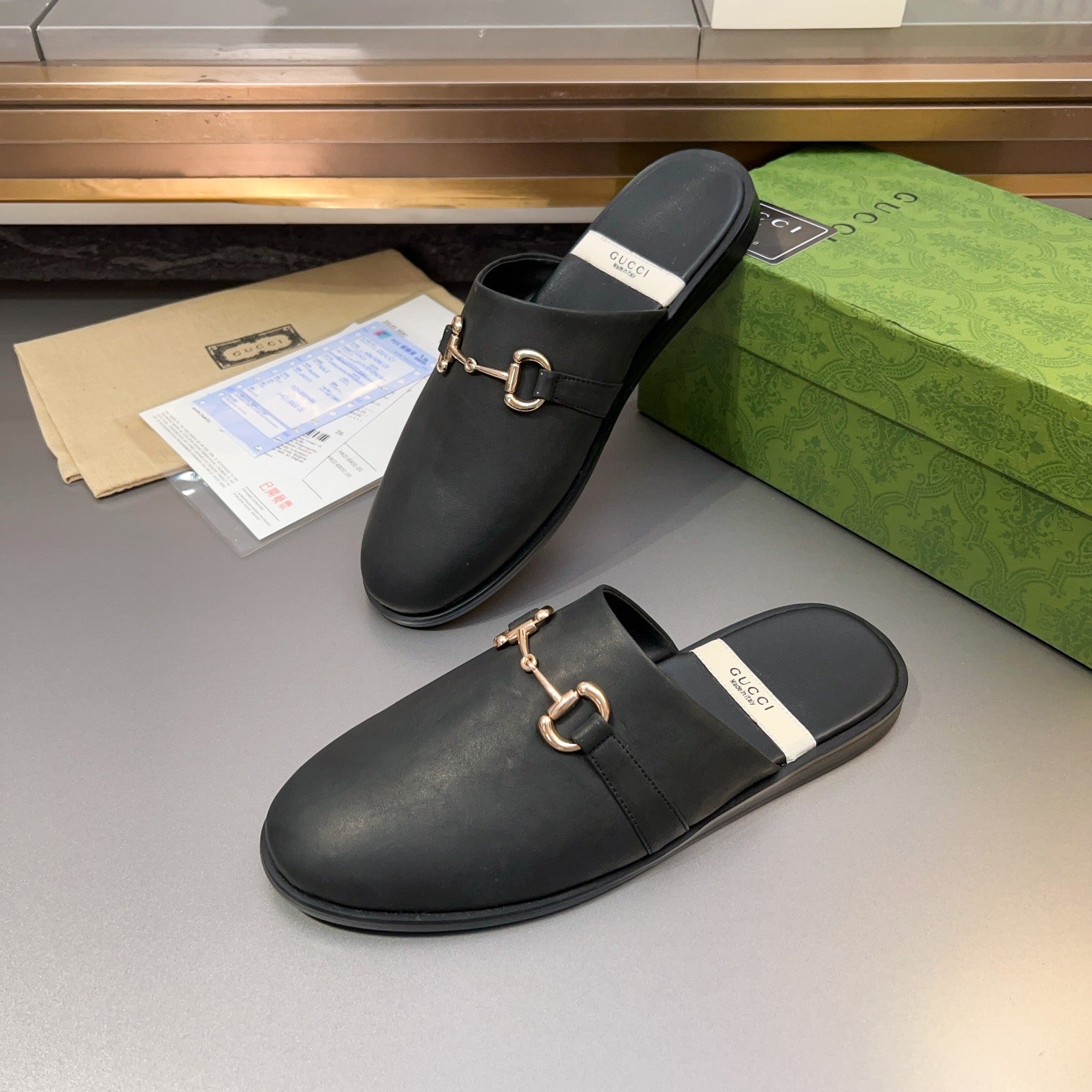 Gucci black leather mule sandal with gold-tone bit buckle and padded strap footbed