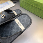 Gucci GG slide sandal with fabric-like insole and gold-tone horsebit hardware, dark upper