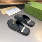 Gucci GG patterned mule sandals with gold-tone horsebit hardware, pair view with black rubber soles