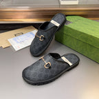 Gucci mule sandals with GG pattern and gold-tone horsebit hardware on dark leather-look uppers