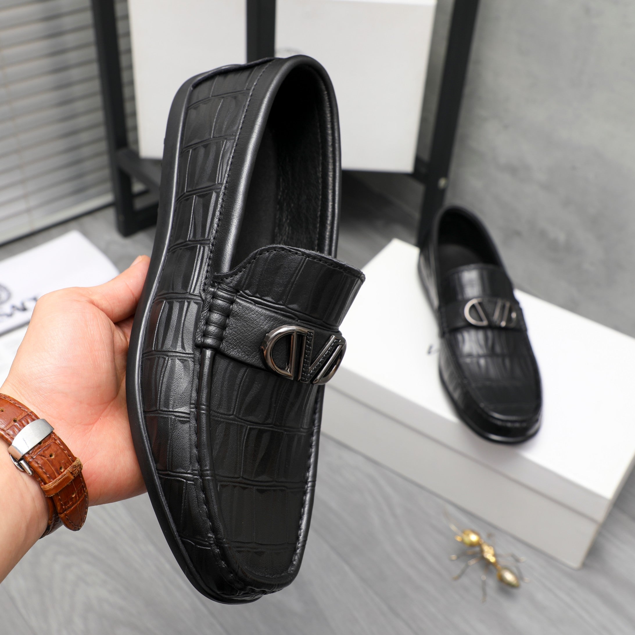 Black leather loafer with embossed texture and metal buckle strap detail