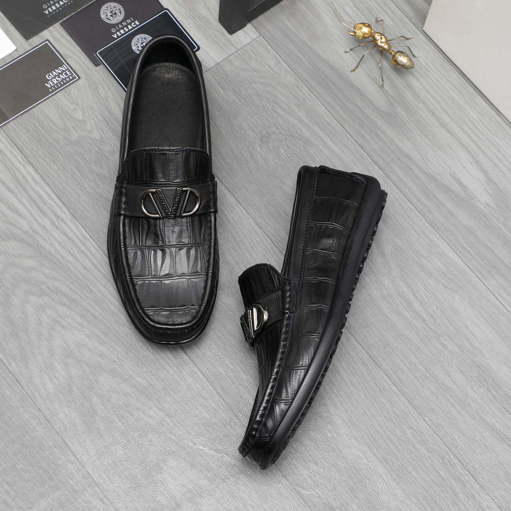 Black leather loafers with embossed texture and metal buckle, side and front view