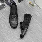 Black leather loafers with embossed texture and metal buckle, side and front view