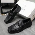 Black leather loafers with embossed texture and metal buckle, angled view