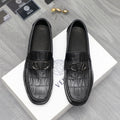 Black leather loafers with embossed crocodile texture and V-shaped metal buckle