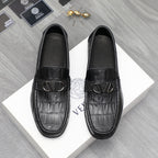 Black leather loafers with embossed crocodile texture and V-shaped metal buckle
