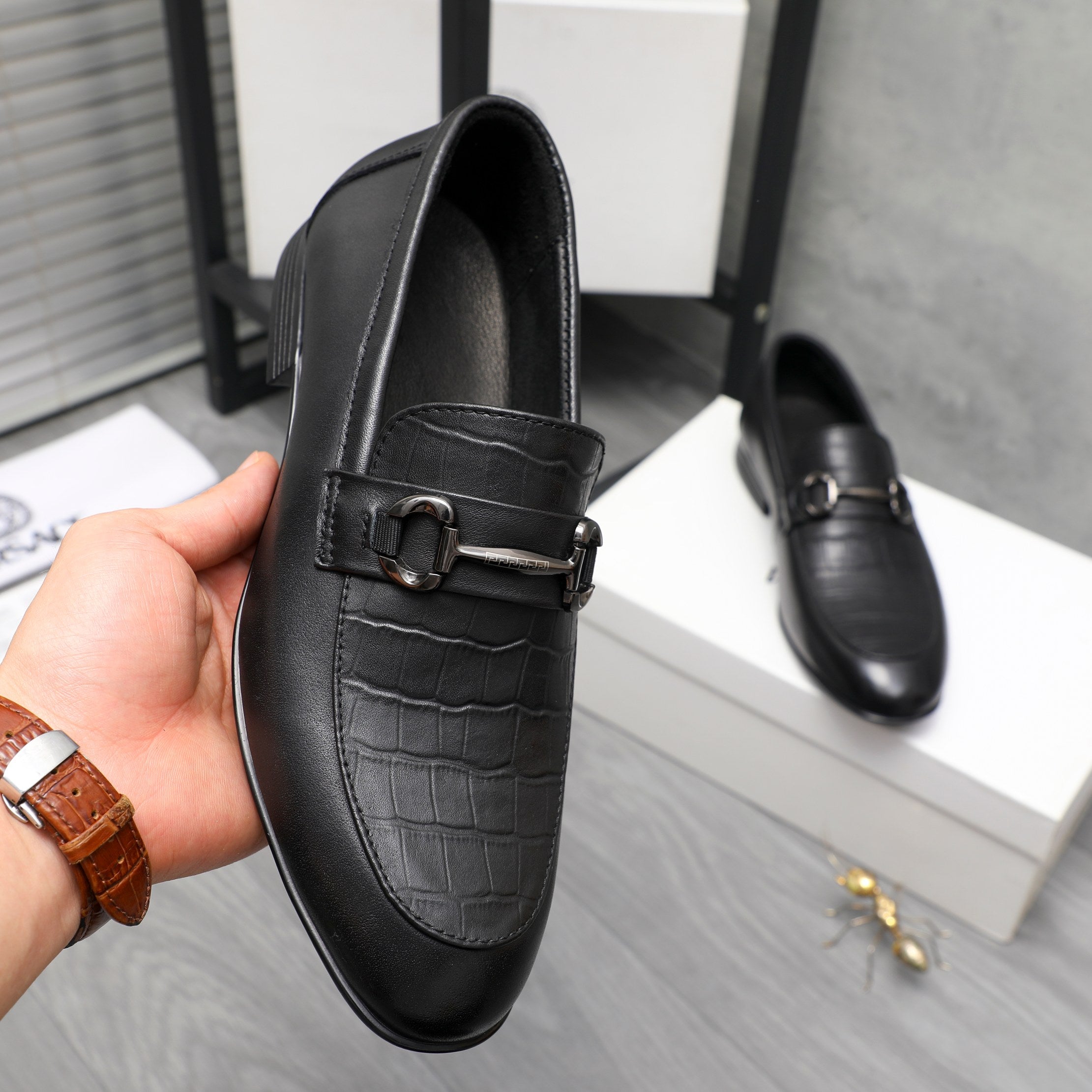 Black leather loafer with metal buckle strap and croc-embossed vamp