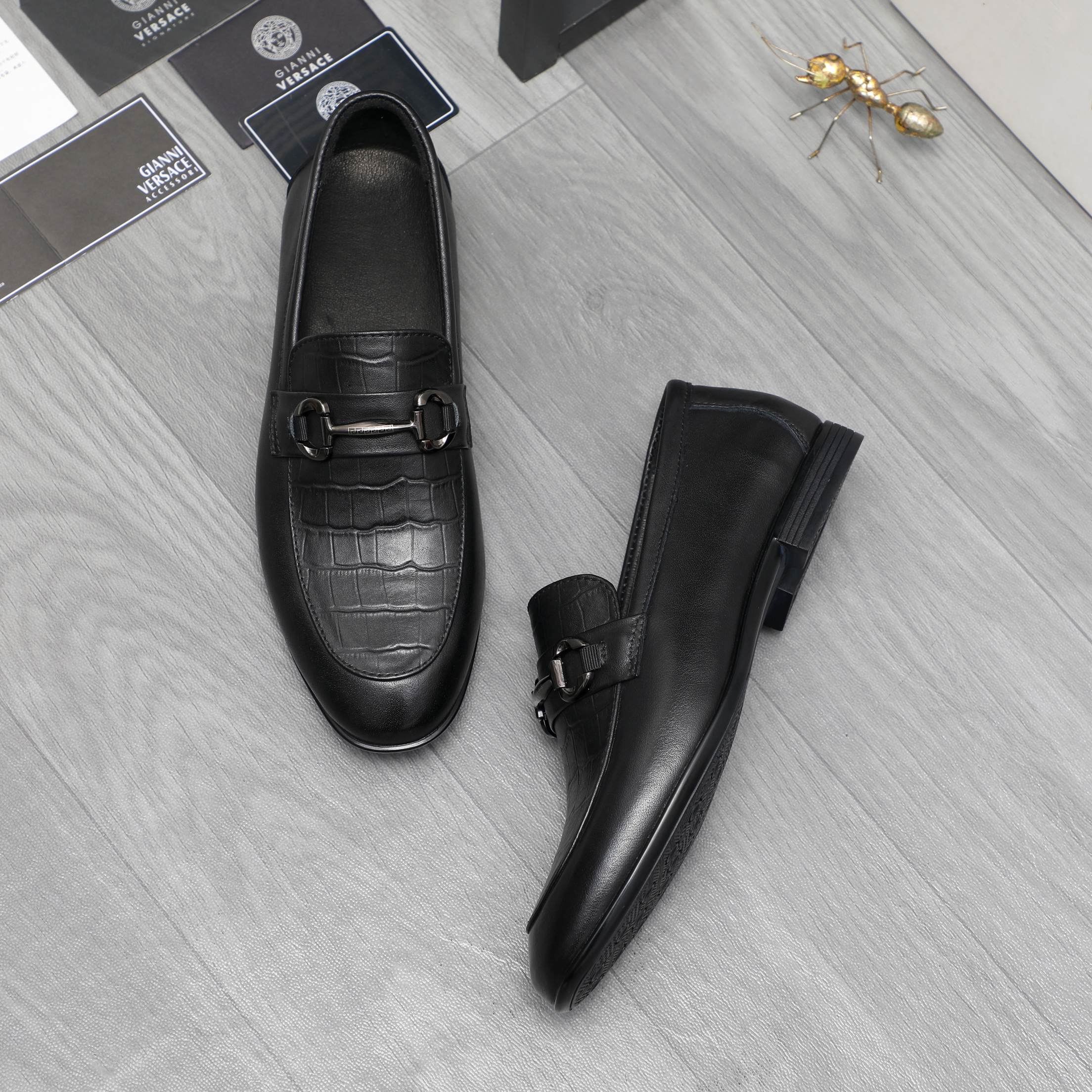 Leather loafer set in black with metal strap buckle and low block sole