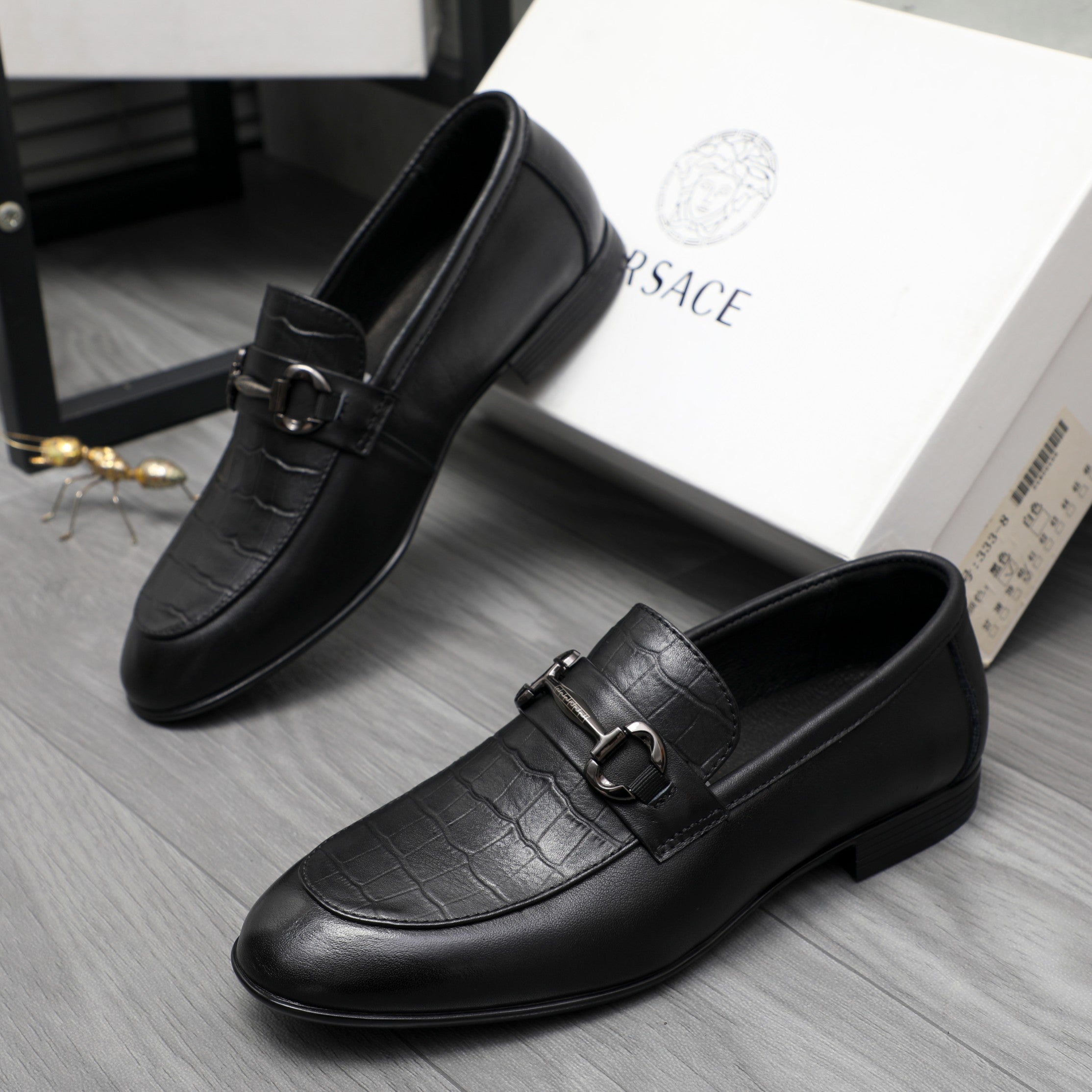 Black leather loafer with strap buckle detail and rounded moc toe