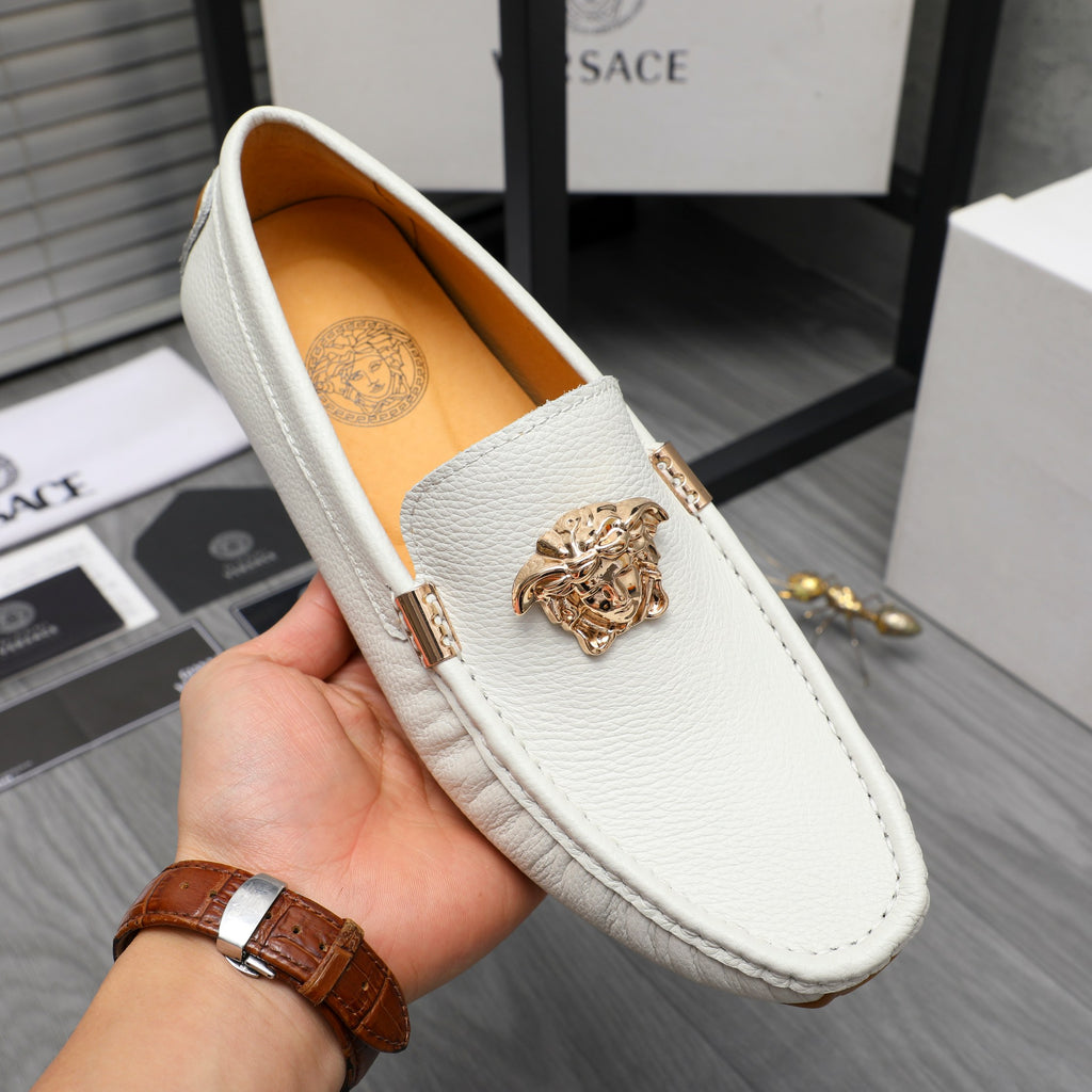 White leather slip-on loafer with gold emblem, open view of interior