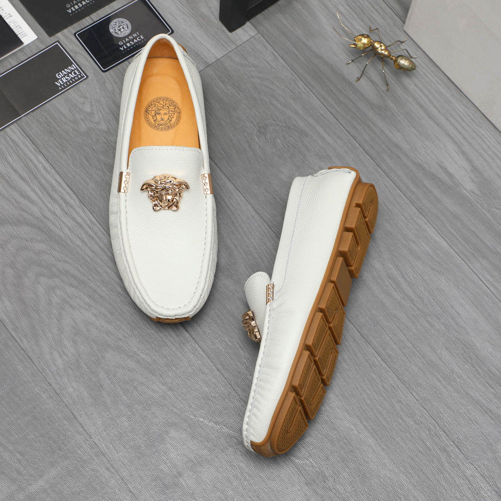 White leather loafers with gold emblem and brown tread sole, side view