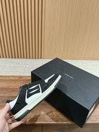Amiri sneaker side view, black glitter with white logo panel, black laces, thick sole
