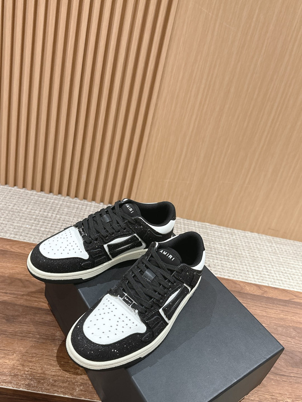 Amiri low-top sneakers pair, black glitter with white toe and side panels, lace-up