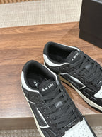 Amiri low-top sneakers close view, black glitter texture, white side stripes, lace-up
