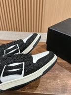 Amiri low-top sneakers close-up, black glitter with white panels, black laces